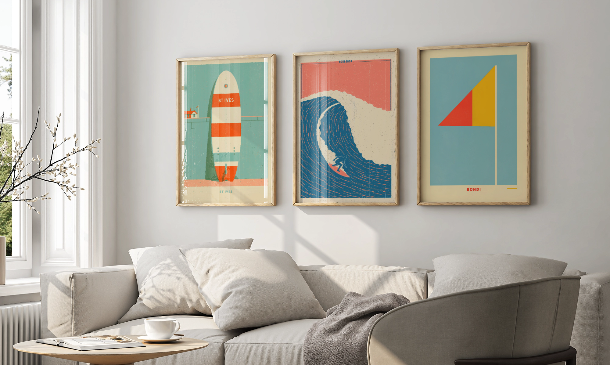 Three framed art prints with retro surfboard and wave designs hang on a light gray wall above a modern beige sofa in a bright living room.